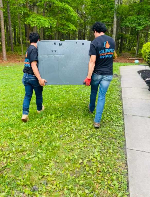 Two Cool Temp technicians carrying HVAC equipment