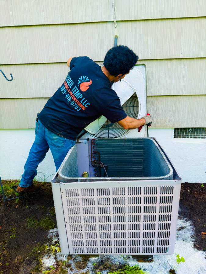 Cool Temp technician servicing an outdoor AC unit