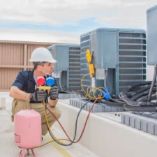 Service HVAC tech repairing a roof top HVAC unit